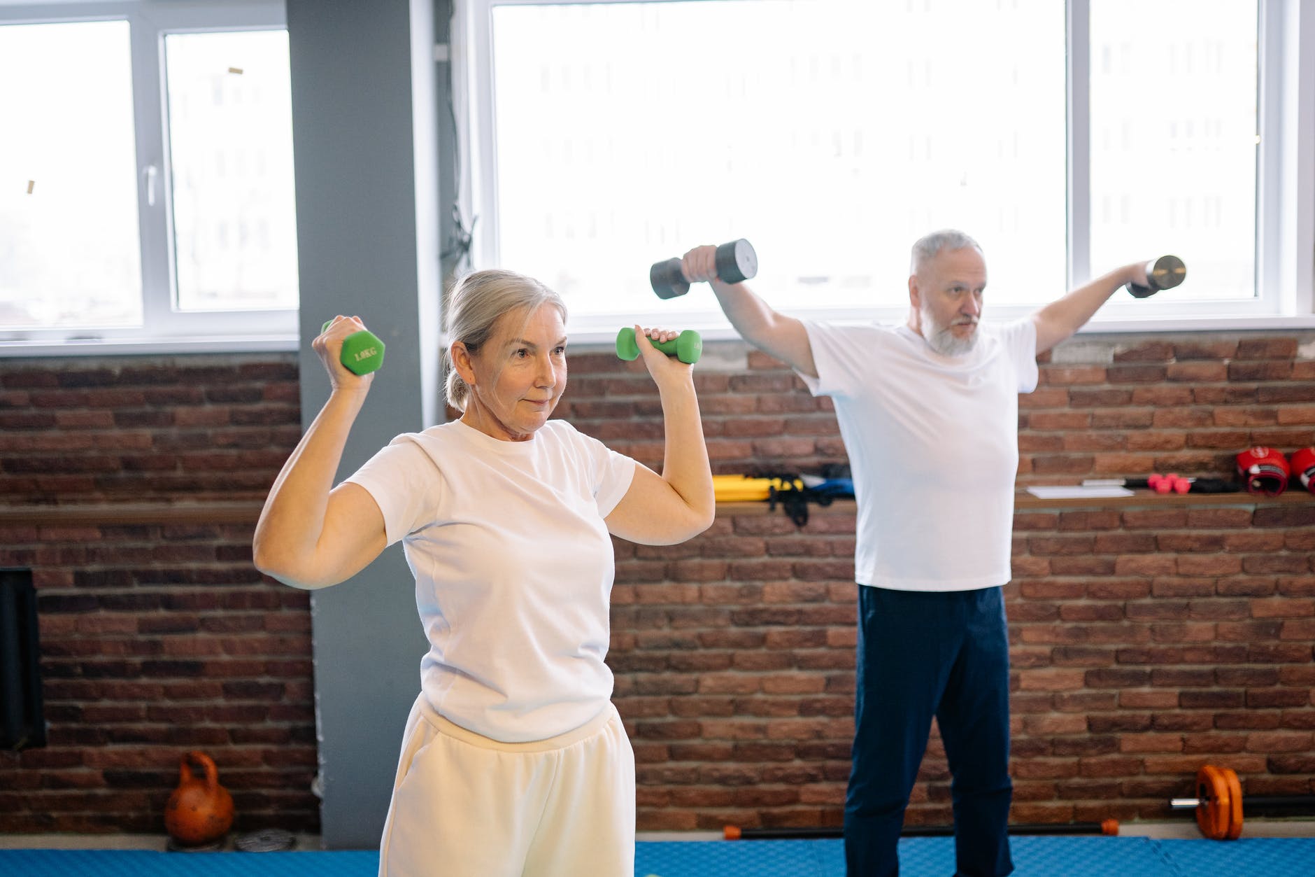 man and woman lifting dumbbells