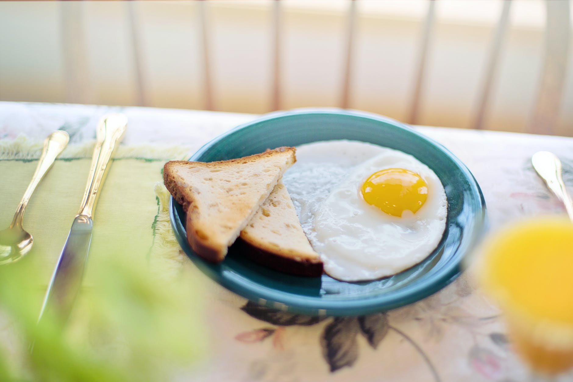 a toasted bread and fried egg on a ceramic plate