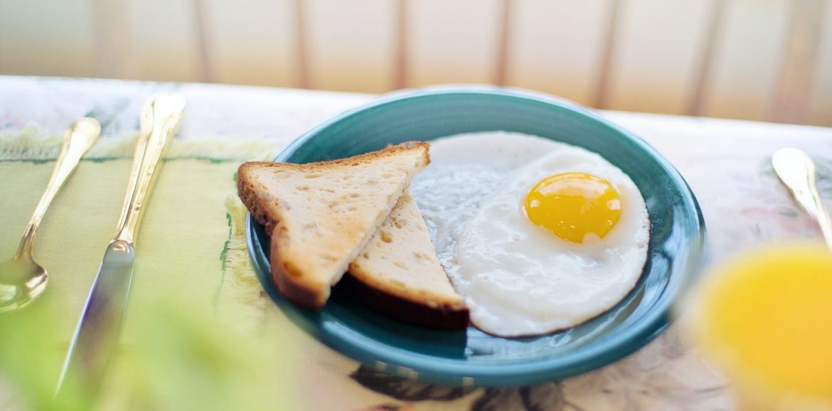 a toasted bread and fried egg on a ceramic plate